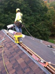 Človek pracujúci na oprave strechy